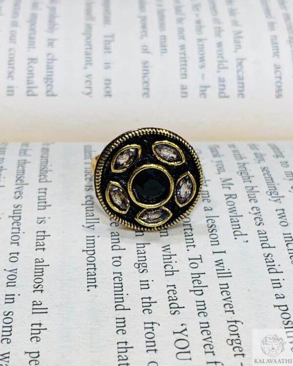 Traditional adjustable ring with a black gem and surrounding white stones in vintage design.