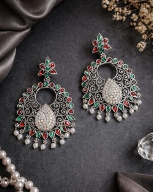 Multicolour stone oxidised silver statement earrings with filigree work and pearl danglers on dark background