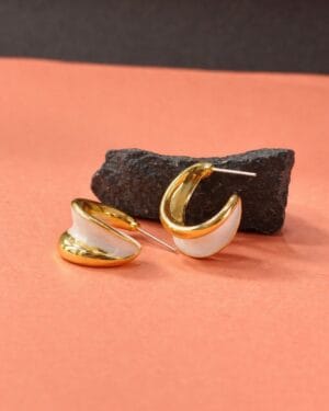 Gold finish half hoop stud earrings with white shell inlay on peach background