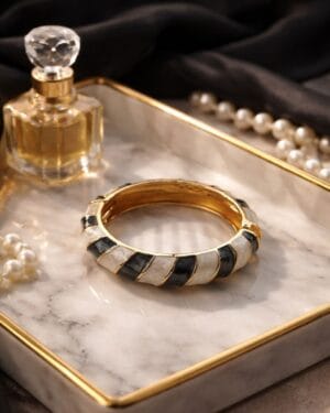 Gold toned black white resin openable bracelet worn on hand