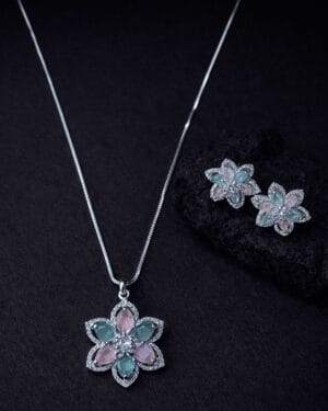 Pastel floral gemstone necklace set with matching earrings in soft pink and mint tones on dark background