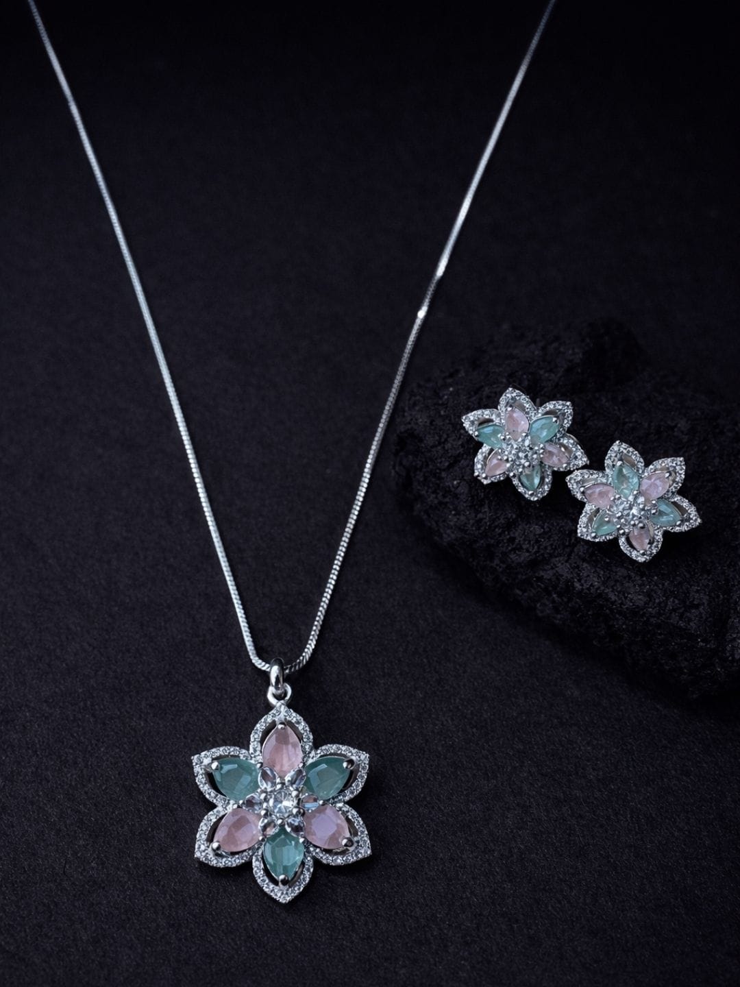 Pastel floral gemstone necklace set with matching earrings in soft pink and mint tones on dark background